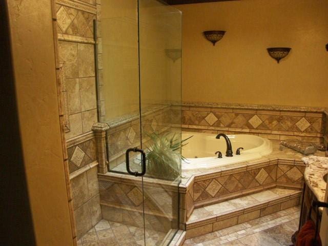 full bath featuring vanity, a shower stall, and a bath