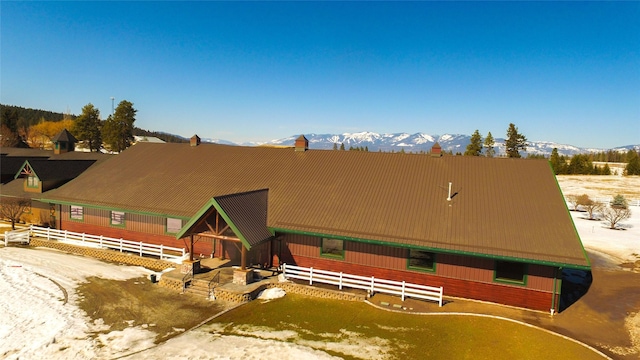 view of front facade with an outbuilding, metal roof, an exterior structure, and a mountain view