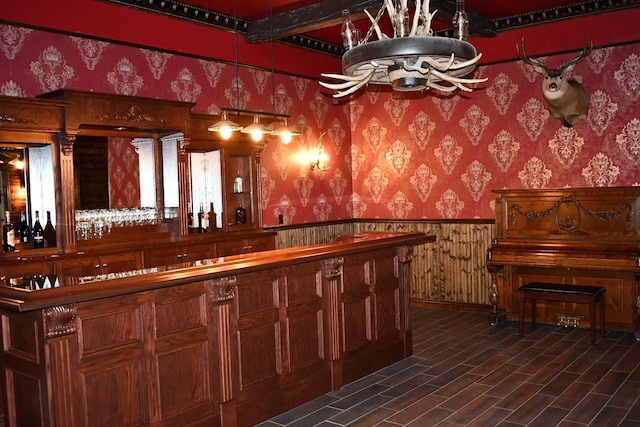 bar with a bar, wainscoting, and wallpapered walls