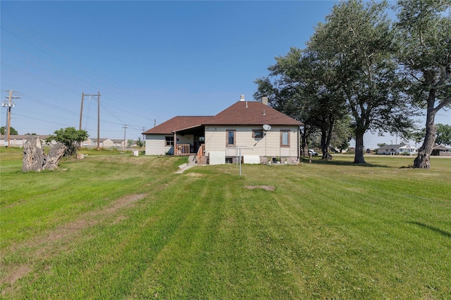 back of house with a yard and a chimney