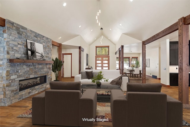 living area with high vaulted ceiling, a fireplace, wood finished floors, and visible vents