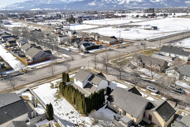 snowy aerial view with a mountain view and a residential view