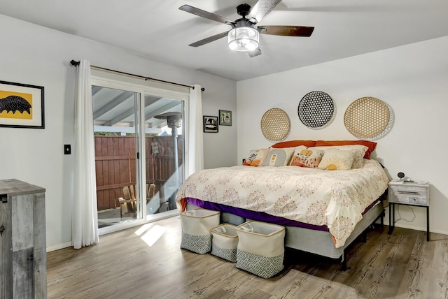 bedroom featuring a ceiling fan, access to outside, baseboards, and wood finished floors