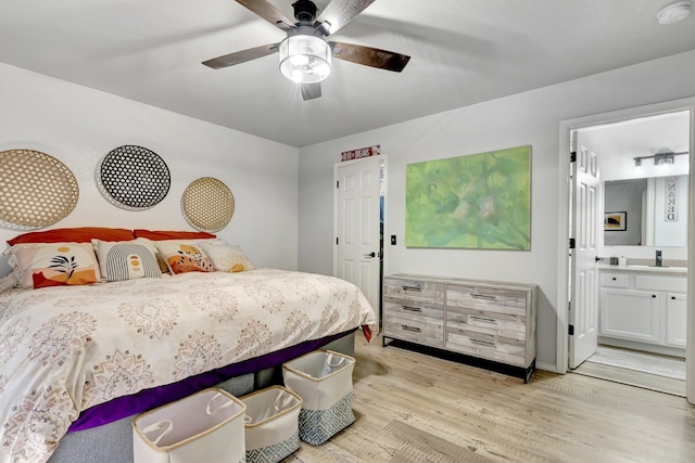 bedroom with ceiling fan, light wood finished floors, a sink, and ensuite bath