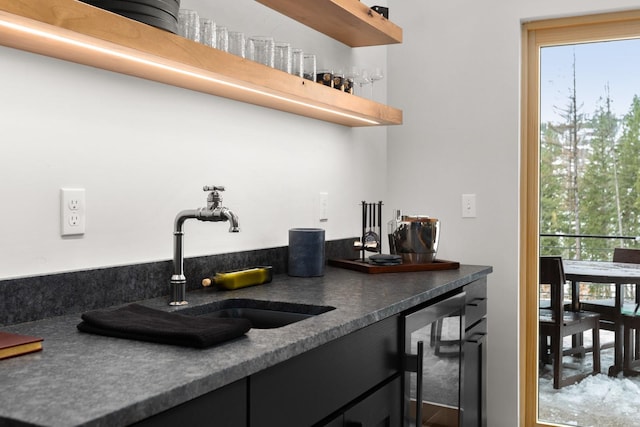 bar with a bar, beverage cooler, and a sink