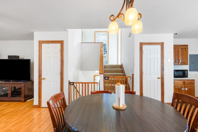 dining area featuring light wood-style floors and stairs