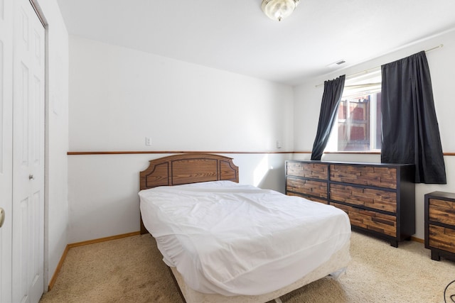 bedroom with light colored carpet and baseboards