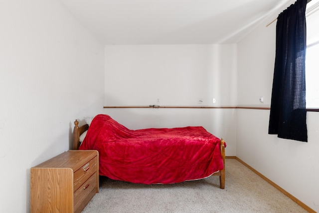 carpeted bedroom featuring lofted ceiling and baseboards