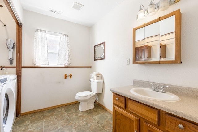 bathroom featuring toilet, vanity, visible vents, and independent washer and dryer