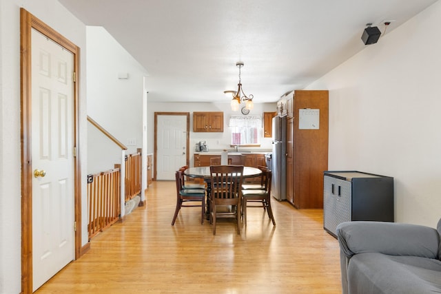 dining area featuring a notable chandelier and light wood-style flooring