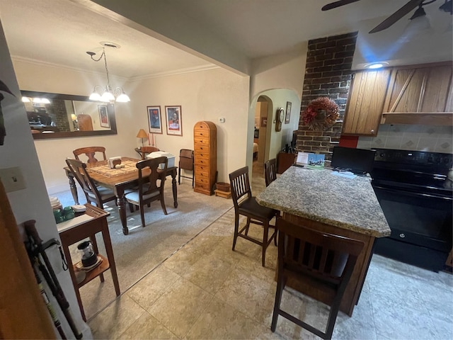 dining room with arched walkways, ceiling fan with notable chandelier, and crown molding