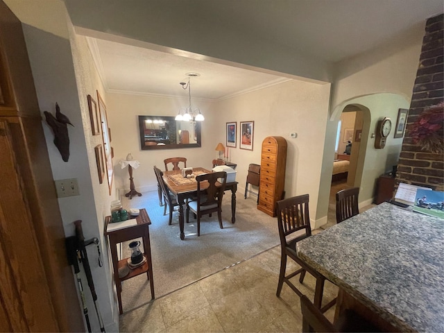 dining space featuring a notable chandelier, baseboards, arched walkways, and crown molding