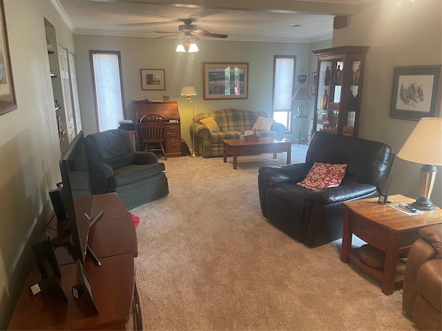 living area featuring a ceiling fan, light carpet, and crown molding