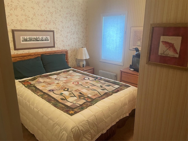 bedroom with wallpapered walls and radiator heating unit