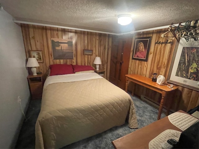 bedroom featuring carpet floors, wood walls, and a textured ceiling