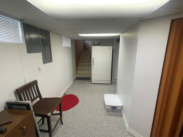 finished basement with stairway, carpet, electric panel, and baseboards