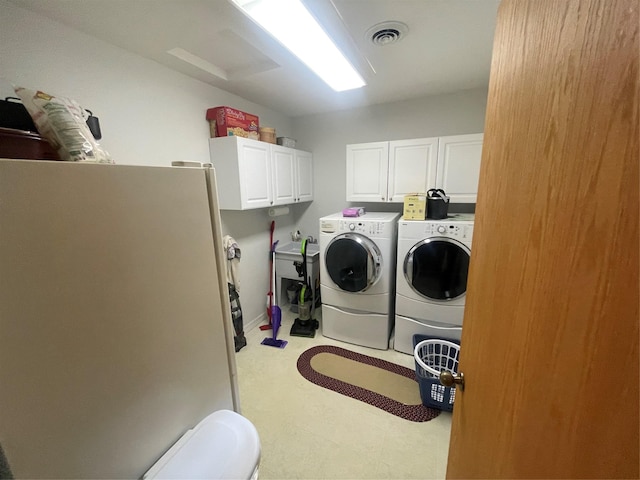 washroom featuring cabinet space, attic access, visible vents, and washer and dryer