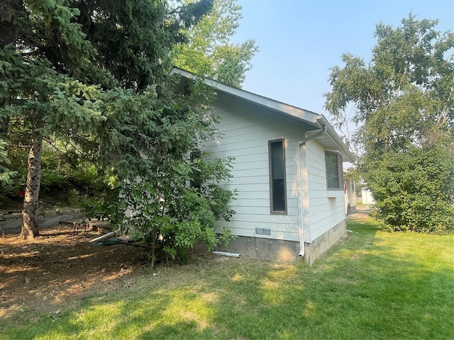 view of side of home with a yard and crawl space