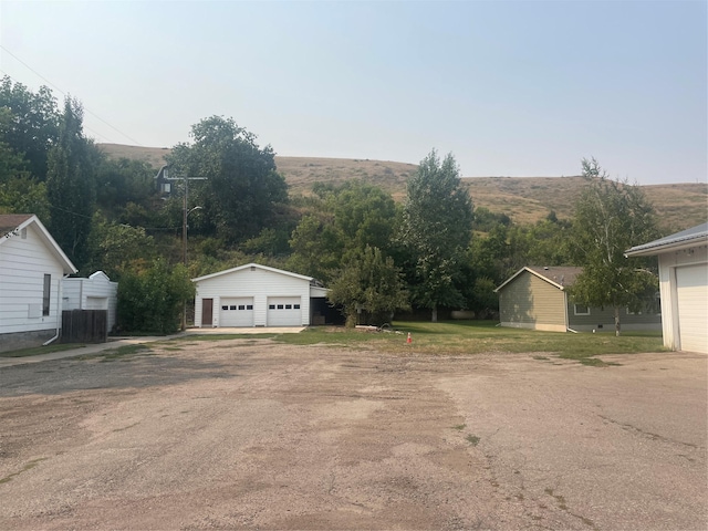 view of side of home with a detached garage, an outdoor structure, and central air condition unit