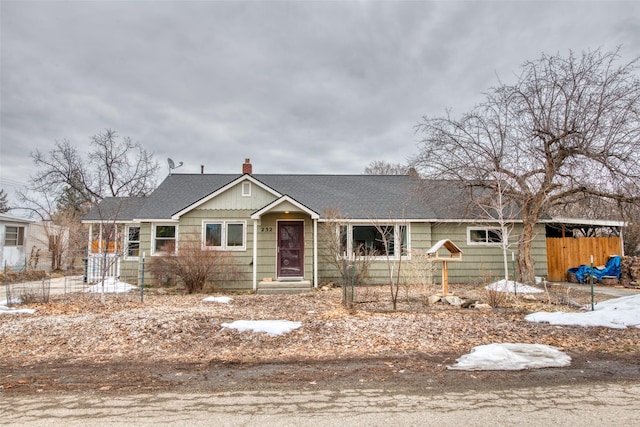 single story home with a shingled roof and a chimney