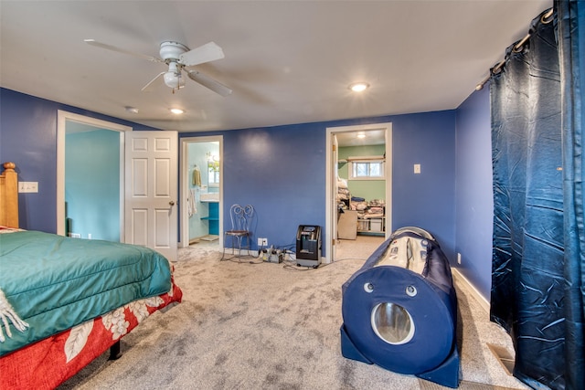 carpeted bedroom with connected bathroom, a ceiling fan, and baseboards