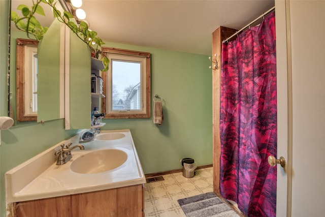 bathroom featuring baseboards, visible vents, a sink, and tile patterned floors