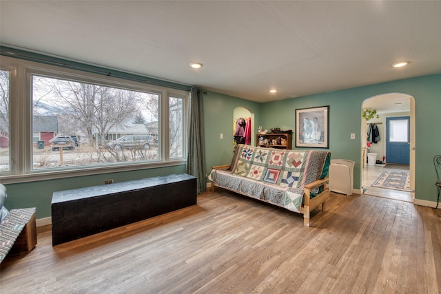 living area with arched walkways, recessed lighting, hardwood / wood-style flooring, and baseboards