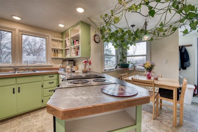 kitchen with open shelves, recessed lighting, a sink, and green cabinetry