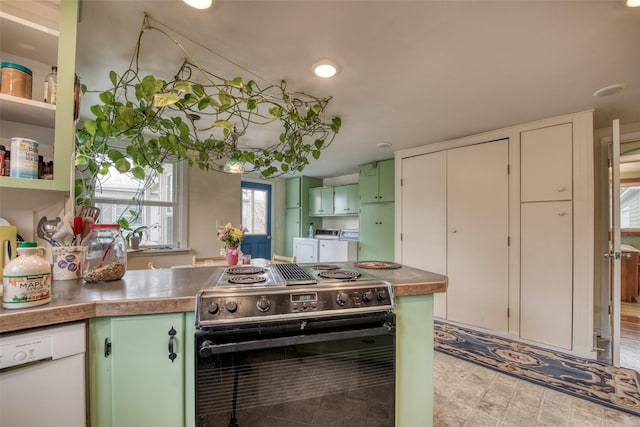 kitchen with stainless steel electric range oven, green cabinets, white dishwasher, washer and dryer, and a peninsula