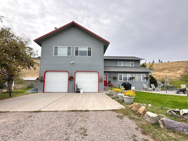 view of front of home featuring concrete driveway, an attached garage, and a front yard