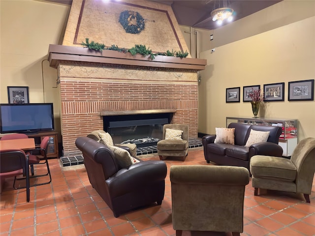 living room with a towering ceiling, tile patterned floors, and a glass covered fireplace