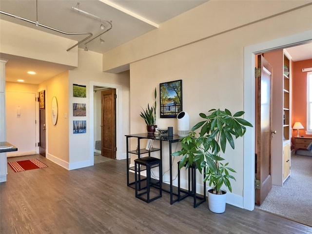 interior space with rail lighting, baseboards, and wood finished floors