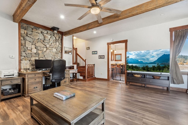 office area featuring ceiling fan, beam ceiling, baseboards, and wood finished floors