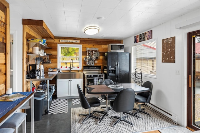 dining area with a baseboard radiator and wooden walls