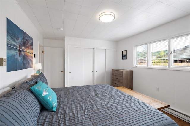 bedroom featuring a baseboard radiator and a closet