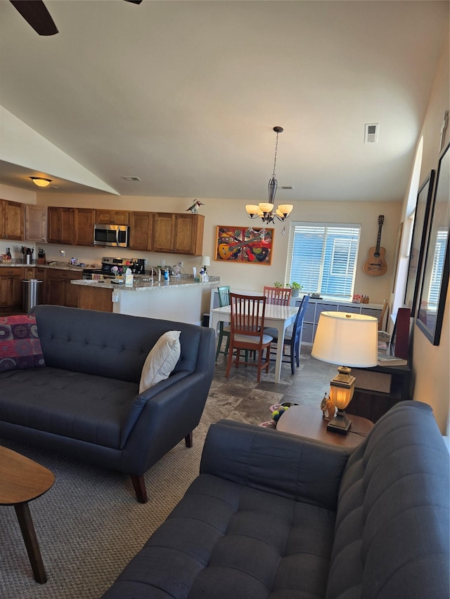 living room with lofted ceiling, visible vents, and a notable chandelier