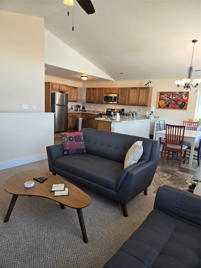 living area with vaulted ceiling, ceiling fan with notable chandelier, and baseboards