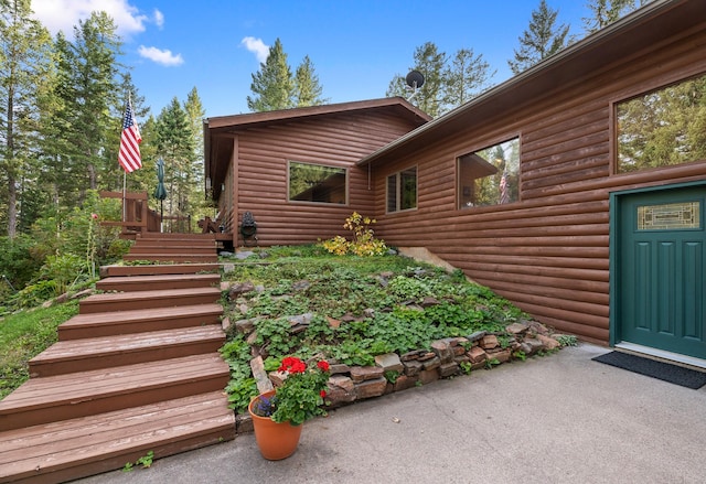 view of exterior entry with a patio area