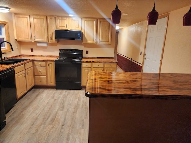 kitchen featuring light wood-style floors, wood counters, black appliances, light brown cabinets, and a sink