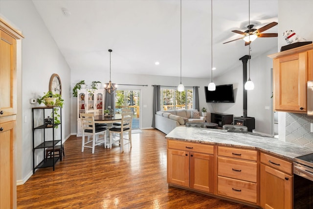 kitchen featuring dark wood-style flooring, vaulted ceiling, a peninsula, and open floor plan