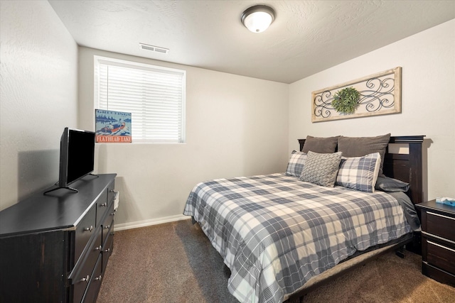 bedroom featuring visible vents, dark carpet, and baseboards