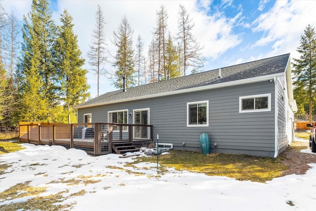 snow covered house featuring a deck