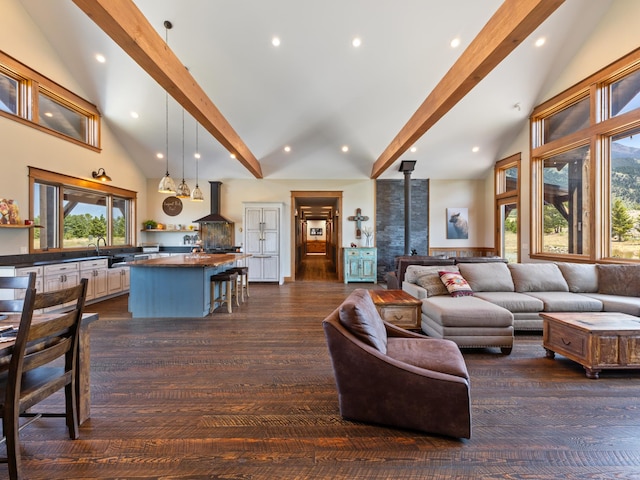 living room featuring a wood stove, dark wood-style floors, high vaulted ceiling, and beamed ceiling