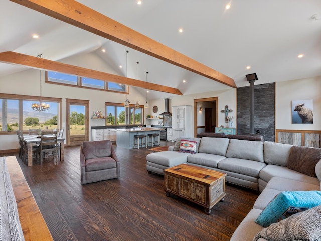 living room with high vaulted ceiling, dark wood-type flooring, beam ceiling, a wood stove, and an inviting chandelier