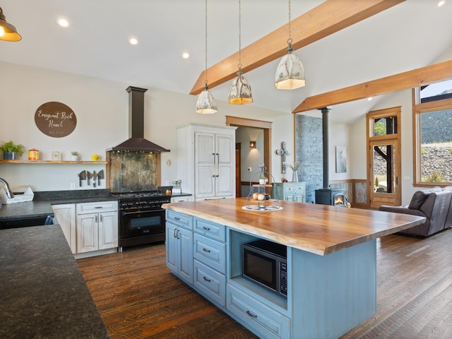 kitchen with a wood stove, wall chimney range hood, double oven range, open shelves, and a sink