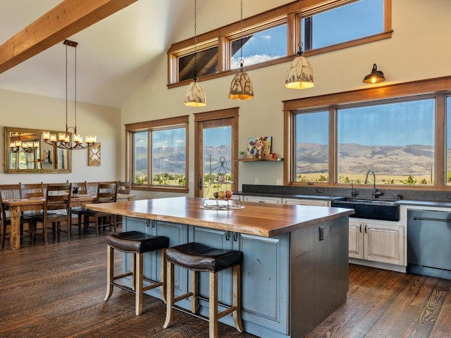 kitchen featuring dark wood-type flooring, a sink, wooden counters, a center island, and dishwasher