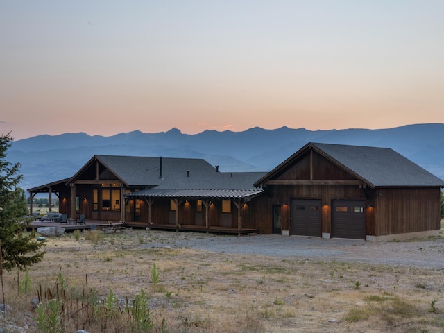 view of front of home with metal roof, a mountain view, driveway, and a standing seam roof