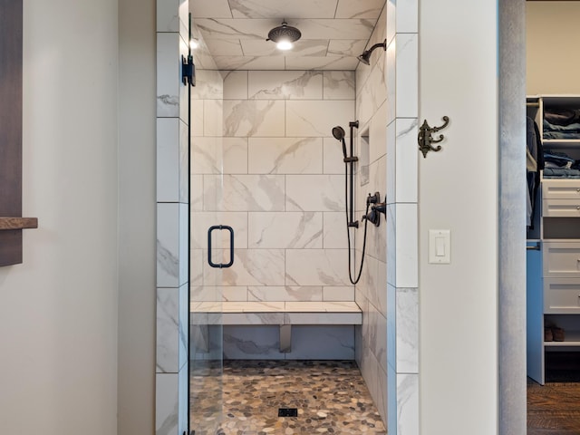 bathroom with a shower stall and a spacious closet