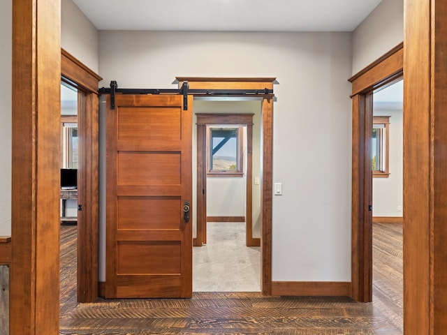 hall with baseboards and a barn door