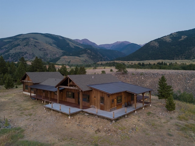 back of house featuring a deck with mountain view, metal roof, and a standing seam roof